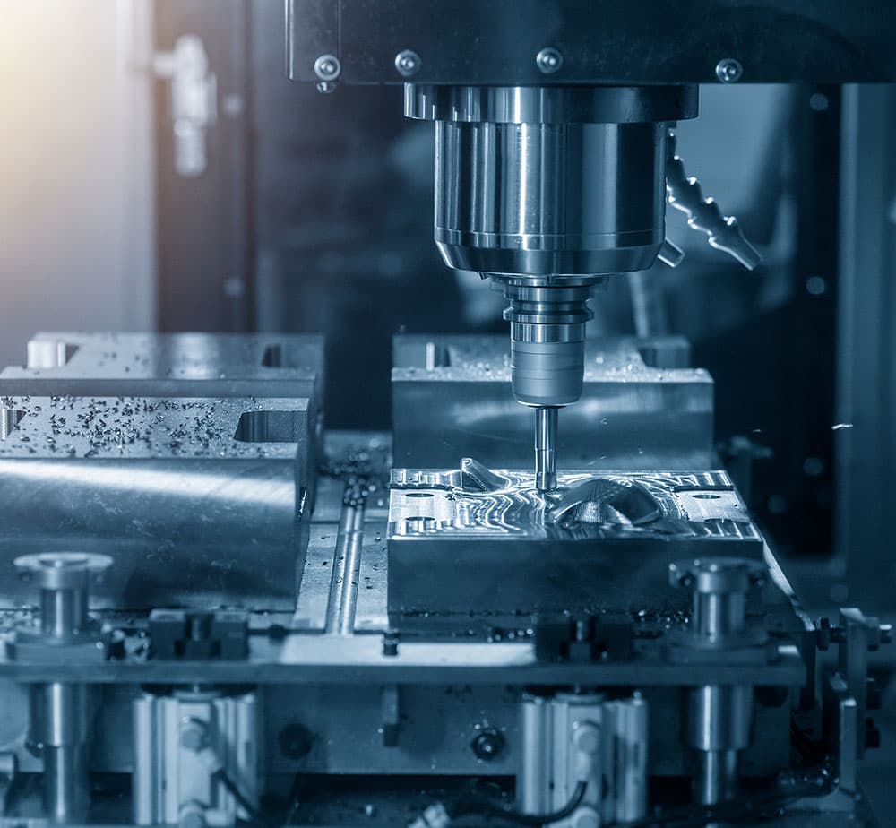 A milling cutter working the cavity of a steel tool block on a machining centre.